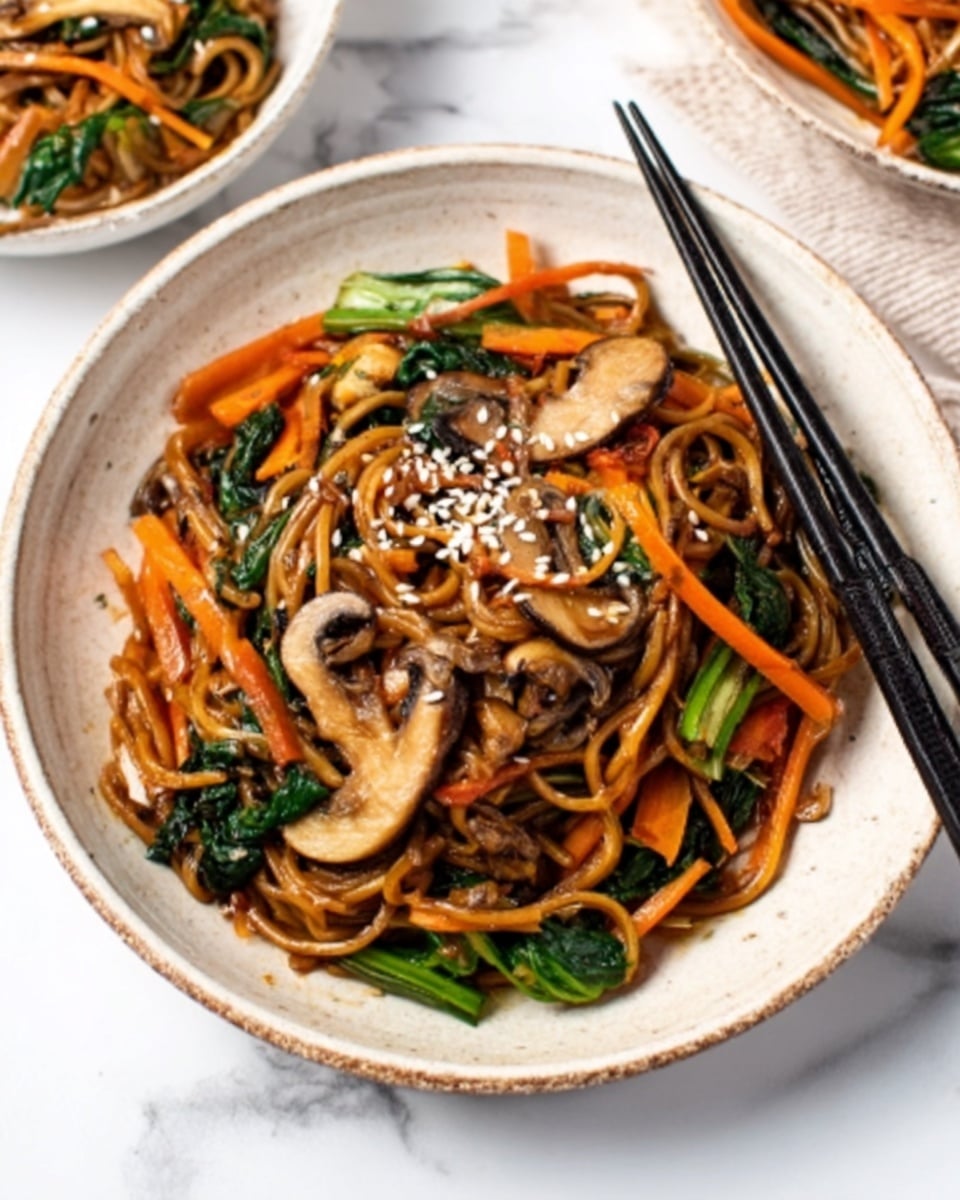 The dish shows a deep white bowl filled with stir-fried noodles mixed with long orange carrot strips and green leafy vegetables. On top, there are sliced brown mushrooms and a sprinkling of white sesame seeds. A pair of black chopsticks rests on the bowl's edge. The background surface is white marble, and there is another similar bowl partially visible at the top left corner. Photo taken with an iphone --ar 4:5 --v 7