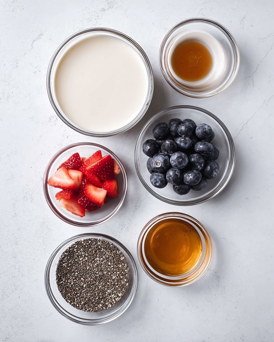 The image shows six small glass bowls on a white marbled surface, each holding a different ingredient. The biggest bowl on the left is filled with a smooth, creamy white liquid. To the right are five smaller bowls: one at the top containing a light brown syrup, below it a bowl of fresh, dark blue blueberries, and beneath that, a bowl full of tiny, black chia seeds with white specks. On the bottom left, there is a bowl with several red strawberries cut into smaller pieces. Finally, the last small bowl at the bottom right contains a golden brown syrup. All the bowls are clear glass with visible reflections, and the lighting is bright and even, creating soft shadows. photo taken with an iphone --ar 4:5 --v 7