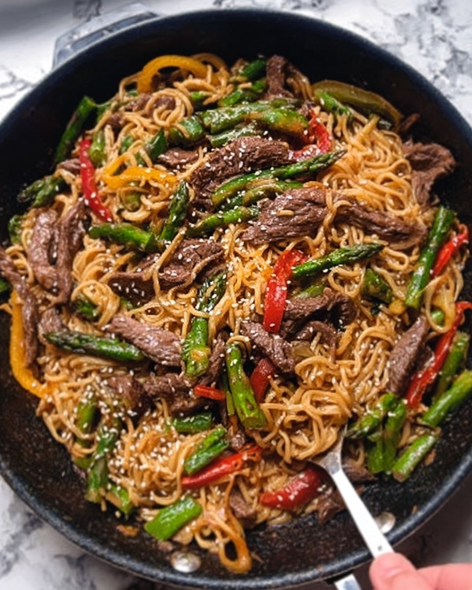 The image shows a black pan filled with a stir-fry dish. The bottom layer is golden brown noodles, mixed with slices of brown cooked beef and bright green asparagus pieces. There are also thin slices of red and yellow bell peppers scattered throughout. White sesame seeds are sprinkled on top of everything, adding small white dots of texture. A woman's hand is holding a silver utensil, partially visible on the right side of the pan. The pan is placed on a surface with a white marbled texture photo taken with an iphone --ar 4:5 --v 7