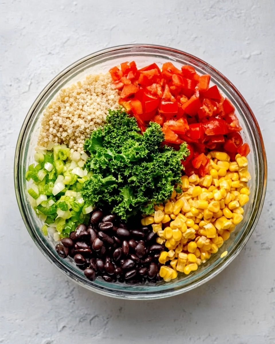 A top view of a clear glass bowl placed on a white marbled surface, divided into five sections filled with different ingredients. Starting from the top right: bright red diced tomatoes, next to a section of small white grains, possibly cooked quinoa. Moving clockwise, finely chopped light green celery, followed by golden yellow corn kernels, and then shiny black beans. A small bunch of curly dark green kale sits between the tomatoes and beans, adding texture and a leafy touch. The colors create a vibrant and fresh look in the bowl. photo taken with an iphone --ar 4:5 --v 7