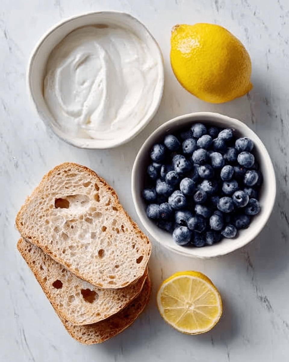 The image shows a white marbled surface with three thick slices of light brown bread with small holes stacked slightly overlapping on the bottom left. Above the bread is a small white round bowl filled with dark blue blueberries, tightly packed and shiny. To the right of the blueberries is a whole yellow lemon with a smooth texture. Above the lemon is a small white bowl with light brown honey and to the left of the honey is a white bowl holding smooth white cream or yogurt. Photo taken with an iphone --ar 4:5 --v 7