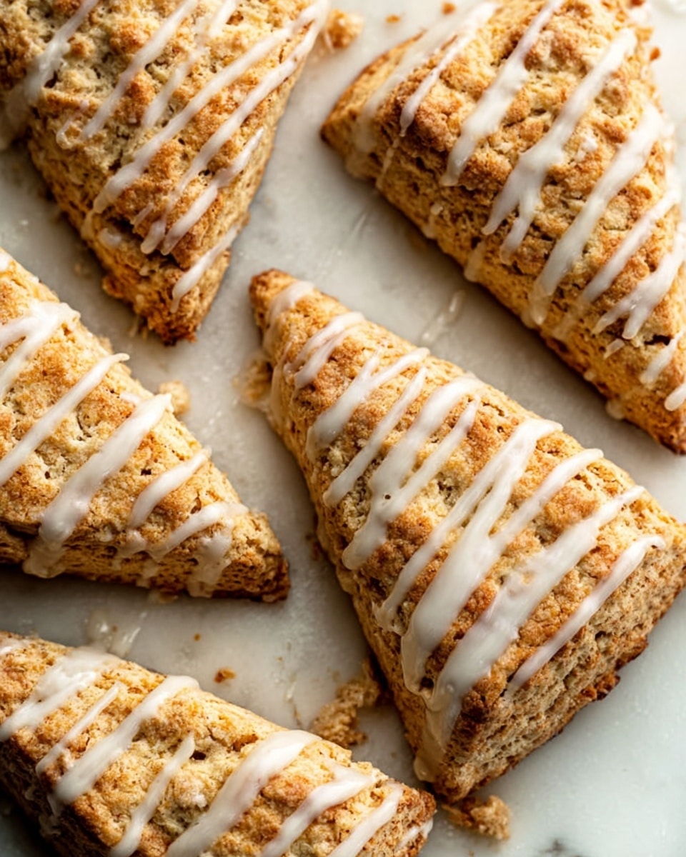 The image shows several triangular scones with a golden brown crust and a crumbly texture. Each scone is drizzled with white icing in thin, uneven lines across the top. The scones are placed on a white marbled surface, with some parts showing a slightly cracked texture. The lighting highlights the crispness of the scones and the glossy finish of the icing. photo taken with an iphone --ar 4:5 --v 7