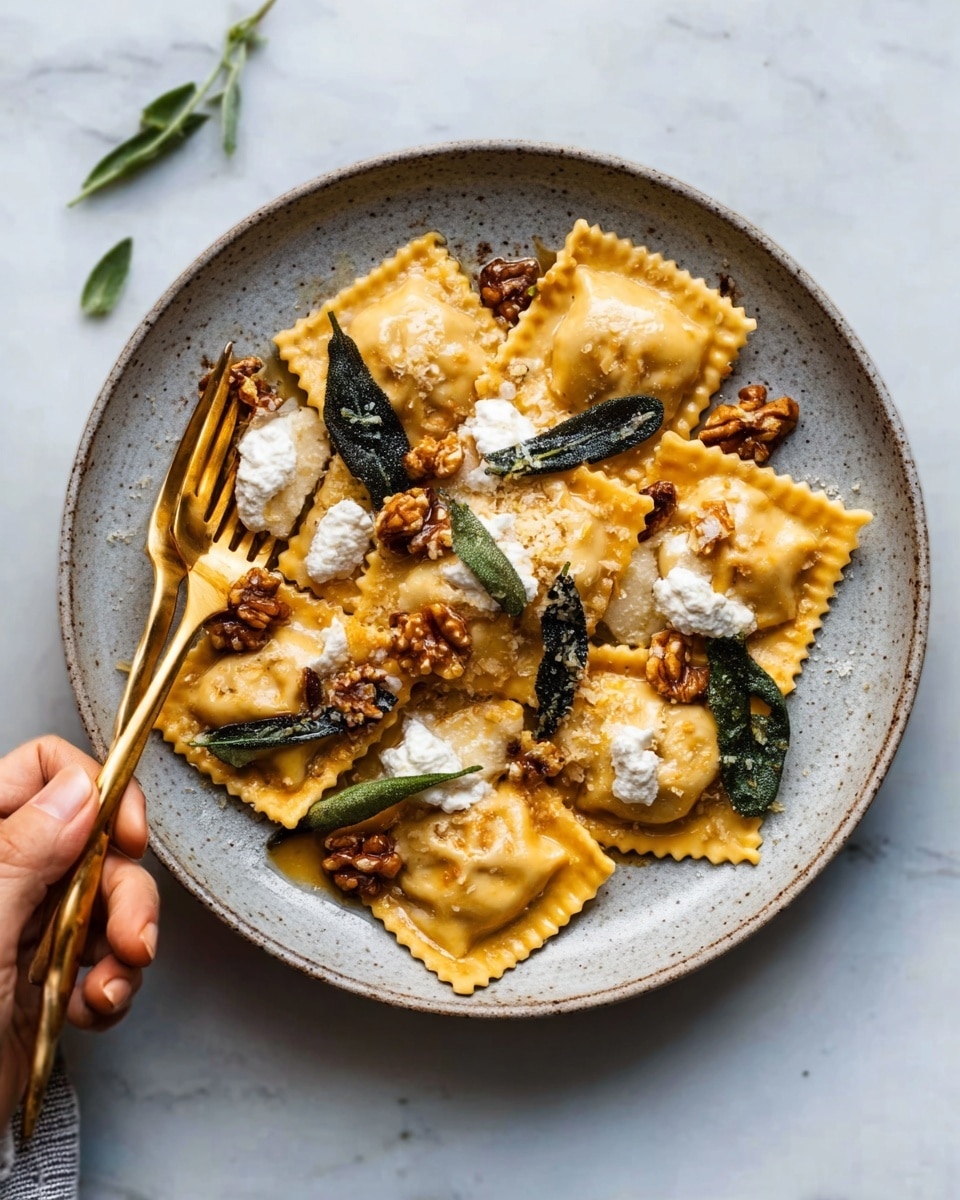 A close-up view of a bowl filled with tortellini pasta covered in a rich, orange sauce with visible herbs and spices. The pasta is golden yellow and slightly shiny, with some pieces folded and overlapping, creating a layered effect. Fresh green sage leaves are placed on top for garnish, adding a pop of color. A fork with a wooden handle rests inside the bowl on a white marbled surface. The bowl itself is white with a subtle texture. Photo taken with an iphone --ar 4:5 --v 7