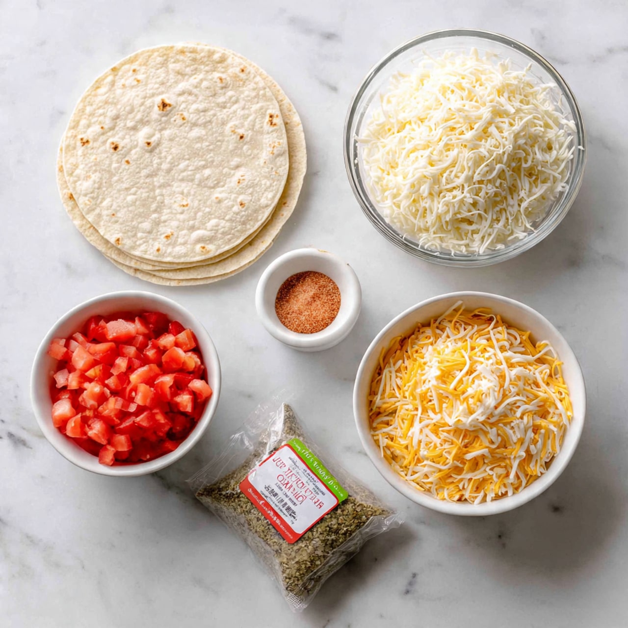 The image shows ingredients arranged neatly on a white marbled surface. There are six whole wheat tortillas stacked one on top of the other in the top left corner. A clear glass bowl filled with white shredded cheese sits to the right of the tortillas. Below this, another white bowl contains a blend of shredded yellow and white cheese. Next to it is a small white bowl of red seasoning powder. At the bottom left, a white bowl holds diced red tomatoes. To the far right, there is a pack of ground beef with a green label. The lighting is bright and natural, emphasizing the fresh and clean look of all the ingredients. Photo taken with an iphone --ar 4:5 --v 7