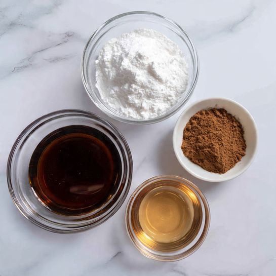The image shows three clear glass bowls on a white marbled surface. The largest bowl at the bottom has a dark brown liquid, smooth in texture and shiny on top. Above it to the left is a medium bowl filled with a white powdery ingredient, smooth and even. To the right of that is a smaller bowl holding a light brown liquid that is clear, smooth, and reflective. Above both smaller bowls is a small white bowl filled with a fine brown powder with a dry, loose texture. All bowls are evenly spaced in a neat arrangement. Photo taken with an iphone --ar 4:5 --v 7