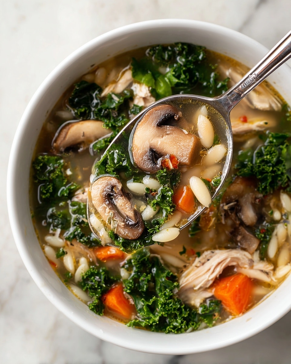 The image shows a close-up of a soup with many layers of ingredients. The top layer has bright green kale leaves with a soft texture, scattered throughout the light brown broth. Mixed in are sliced mushrooms, both whole and quartered, with a smooth, pale beige color and dark gills. Small orange carrot cubes add a pop of color among the greens and mushrooms. White beans and small, pale orzo pasta are spread evenly, giving a varied shape to the soup. Pieces of light beige chicken are also mixed in. A metallic spoon dips into the soup, scooping up a mixture of all ingredients, showing the clear broth’s slight shine. The soup is against a white marbled texture background. photo taken with an iphone --ar 4:5 --v 7