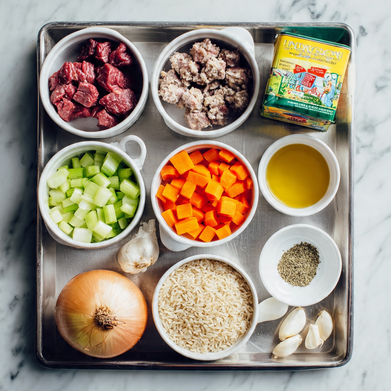 The image shows a metal tray with several small white bowls and containers holding raw cooking ingredients, all arranged neatly. In one bowl there are shiny raw beef pieces, dark red in color and irregular in shape. Next to it is a green and yellow soup carton and a white can with a colorful label. The tray also holds orange diced carrots in a white bowl, pale green chopped celery in another white bowl, and a single unpeeled brown onion. There is a bowl with uncooked brown rice grains, a small bowl with amber-colored liquid, and a few cloves of garlic beside a small bowl of ground herbs or spices. Everything is set on a white marbled surface, photo taken with an iphone --ar 4:5 --v 7