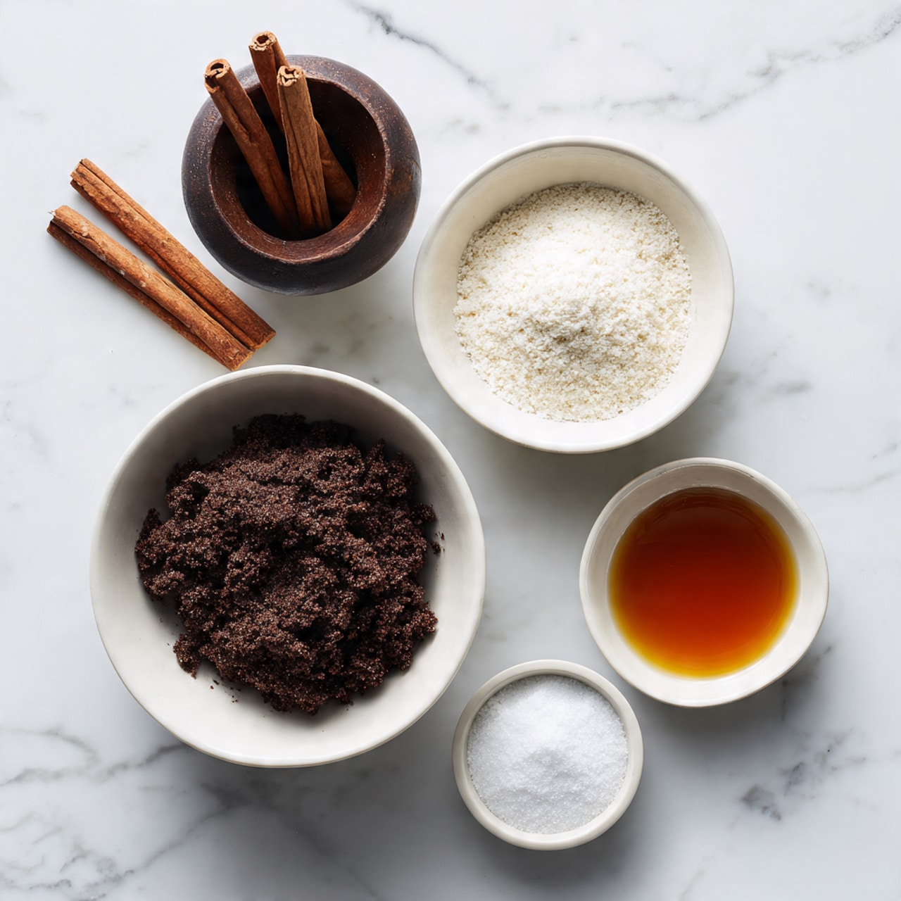 The image shows four white bowls placed on a white marbled surface, each with a different ingredient. The largest bowl contains a dark brown crumbly mixture filling it almost to the top. Below it, a medium bowl holds fine white granules. To the right of the largest bowl, there is a small bowl filled with a dark amber liquid, and next to it is another small bowl with a white powdery substance. In the top left part of the image, there is a dark wooden cup with what looks like cinnamon sticks inside. The setup is simple and clean, with the colors of the ingredients standing out against the white bowls and background. photo taken with an iphone --ar 4:5 --v 7