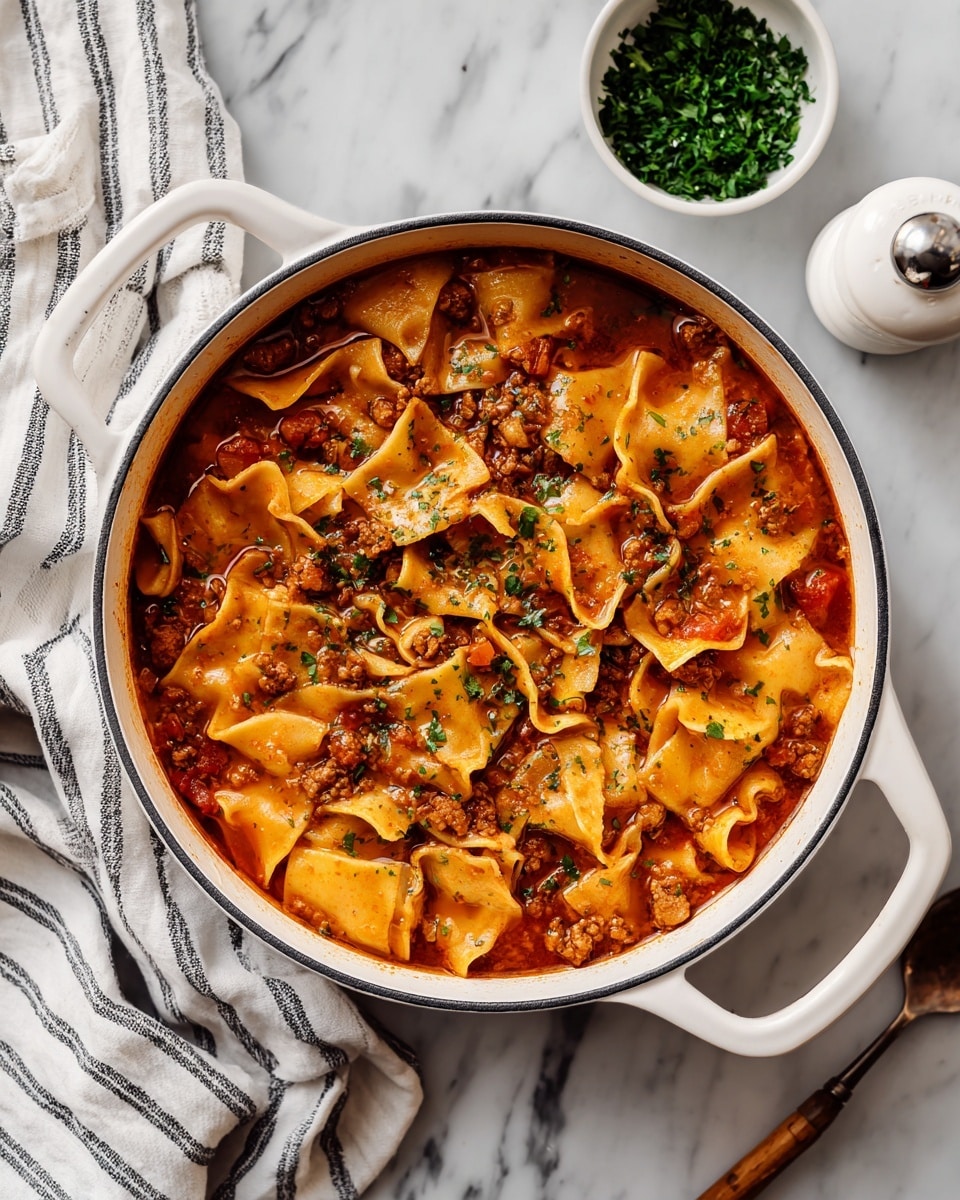 The image shows a white pot filled with a thick soup made of uneven, wide pasta pieces, a reddish-brown broth, small chunks of tomato, green herbs, and bits of ground meat, giving a hearty, mixed texture. The pot has two handles, and it is placed on a white marbled surface with a striped white and gray cloth to the left. Above the pot, there is a small white bowl filled with chopped green herbs and a white pepper grinder on the right side. A spoon lies near the pot on the surface, and a woman's hand with a wooden handle is holding one of the pot’s handles. The photo taken with an iphone --ar 4:5 --v 7