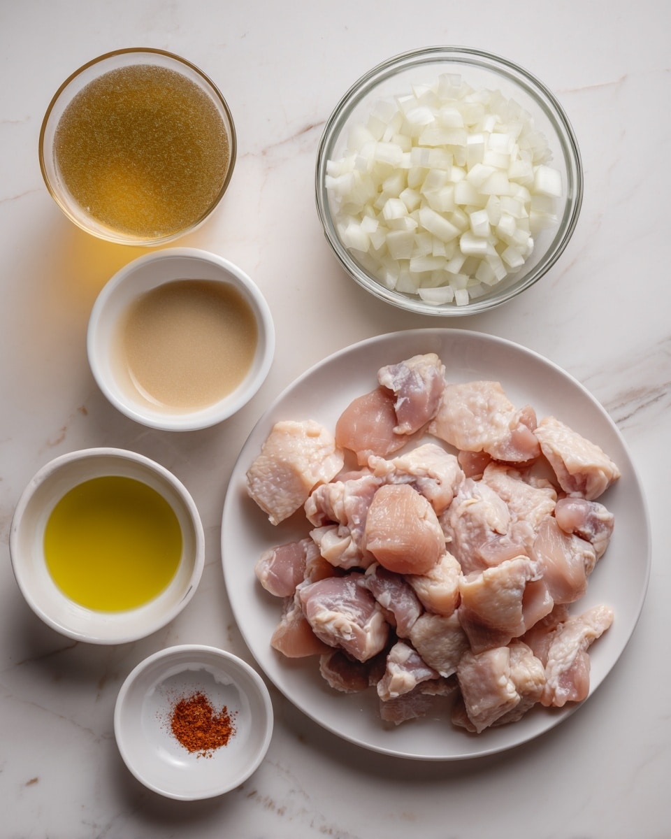 The image shows a white plate filled with raw chicken pieces placed on a white marbled surface. Next to the plate, there is a clear glass bowl containing chopped white onions. Above and to the left of the onions, there is a white bowl with a thick beige liquid. Below the bowl of onions, there is a small white bowl with a golden yellow liquid, likely oil. Near the oil, a small white saucer holds a reddish powder spice. Finally, to the left of the chicken, there is a glass filled with a light brown liquid, possibly broth or sauce. The photo taken with an iphone --ar 4:5 --v 7