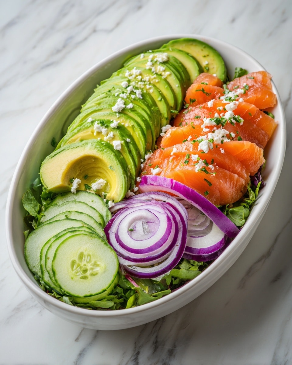 A white oval bowl filled with a fresh salad that has several layers: the bottom is a mix of green leafy vegetables, topped with bright orange pieces of salmon, thin slices of cucumber and avocado arranged in a fan shape, thin rings of purple onion, and sprinkled with small white crumbles of cheese. The salad looks colorful and vibrant against a white marbled surface. photo taken with an iphone --ar 4:5 --v 7