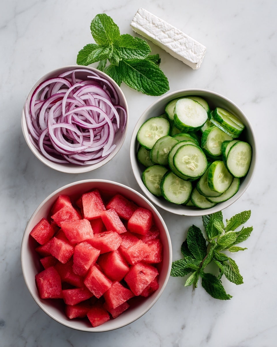 The image shows four white bowls on a white marbled surface. The largest bowl at the bottom contains many small, red cubes of watermelon neatly packed. Above it and slightly to the right is a smaller bowl filled with sliced green cucumbers arranged in a circular pattern. To the left of the cucumber bowl is another small bowl holding thin slices of purple onions layered loosely. Next to the bowls, fresh green mint leaves are spread out on the surface. A white package of soft cheese is placed above the bowls. Photo taken with an iphone --ar 4:5 --v 7