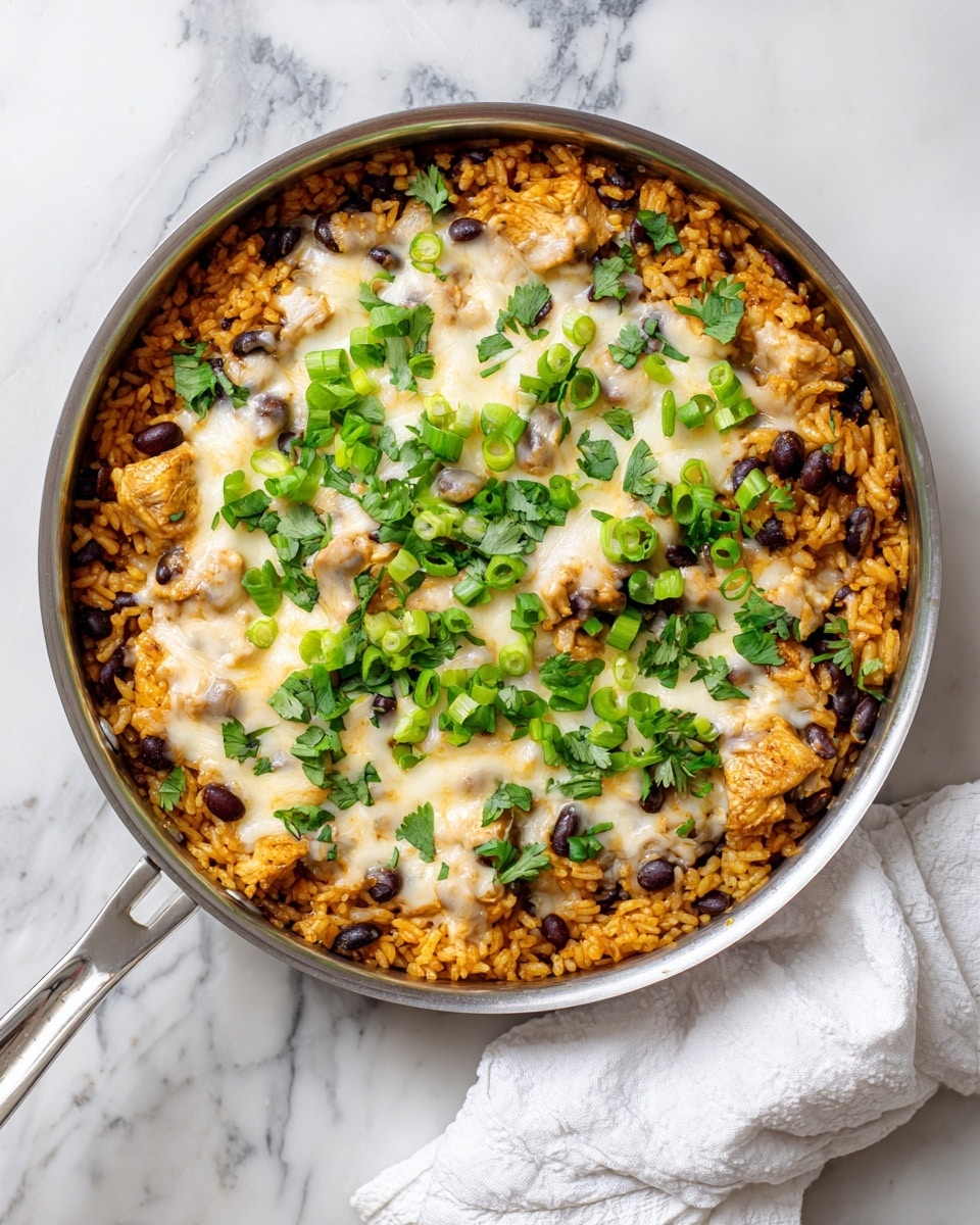 A round metal pan filled with a cooked rice dish that has a mix of orange rice, black beans, and chunks of chicken. The top is covered with a layer of melted white cheese that looks creamy and slightly browned in places. Green sliced scallions and fresh chopped cilantro are scattered on top, adding a bright green color contrast. The pan is set on a white marbled surface, with part of a white cloth napkin visible near the handle. Photo taken with an iphone --ar 4:5 --v 7