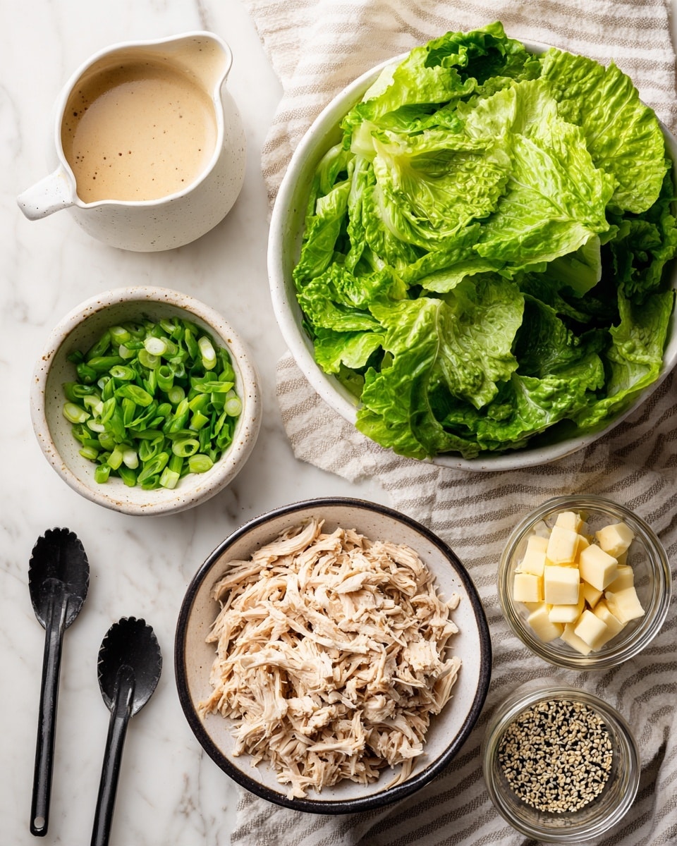 The image shows several bowls and measuring spoons arranged on a white marbled surface with a light beige striped cloth underneath. At the center bottom is a white bowl with a black rim filled with shredded light-colored chicken. Above it is a large white bowl filled with fresh, green leafy lettuce with visible veins and texture. To the left of the lettuce bowl is a small white bowl with chopped green onions. On the far left is a small white pitcher filled with a creamy beige sauce. On the right side are two black measuring spoons holding light yellow cubes of butter and a mix of black and white sesame seeds, with a small glass jar containing more sesame seeds nearby. photo taken with an iphone --ar 4:5 --v 7