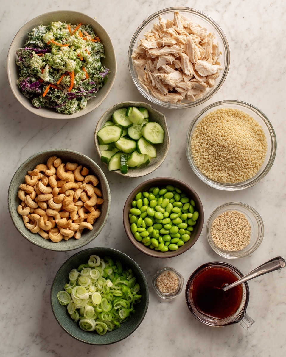 A top-down view of various ingredients arranged neatly on a white marbled surface, including shredded light brown chicken in a clear glass bowl at the top right, fluffy beige quinoa in another clear glass bowl just below it, and a brown bowl filled with chopped green cucumbers near the center. A white bowl of brown roasted cashews is on the left, and a dark green bowl holding sliced green onions is below it. There is a dark gray bowl full of bright green edamame beans towards the bottom right, with a small white bowl of pale sesame seeds above it. On the right side is a clear measuring cup with dark red sauce and a silver spoon inside. A bag of kale slaw with shades of green, orange, purple, and white on the top left completes the setup. Photo taken with an iphone --ar 4:5 --v 7