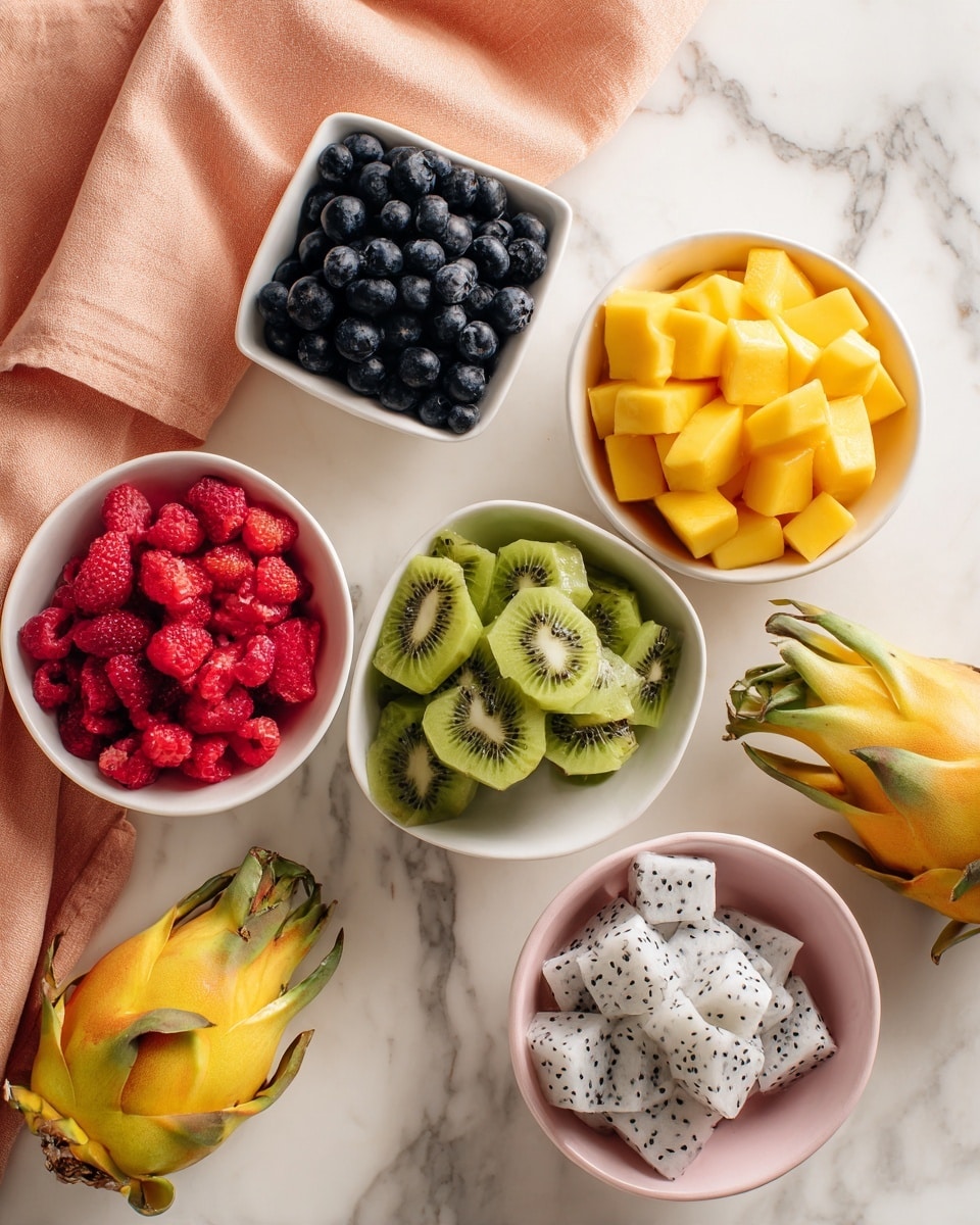 The image shows five white bowls with different fresh fruits arranged on a white marbled surface. The top bowl has dark blue blueberries, the square bowl next to it is filled with bright yellow mango cubes, and below that bowl is a white bowl containing green kiwi slices. To the left, there is a white bowl with bright red chopped strawberries, and to the right bottom side is a pale pink bowl full of white dragon fruit cubes with small black seeds. There is a half yellow dragon fruit with white flesh and another whole yellow dragon fruit with green tips placed near the bowls. A folded peach-colored cloth is partly visible on the top left side. Photo taken with an iphone --ar 4:5 --v 7