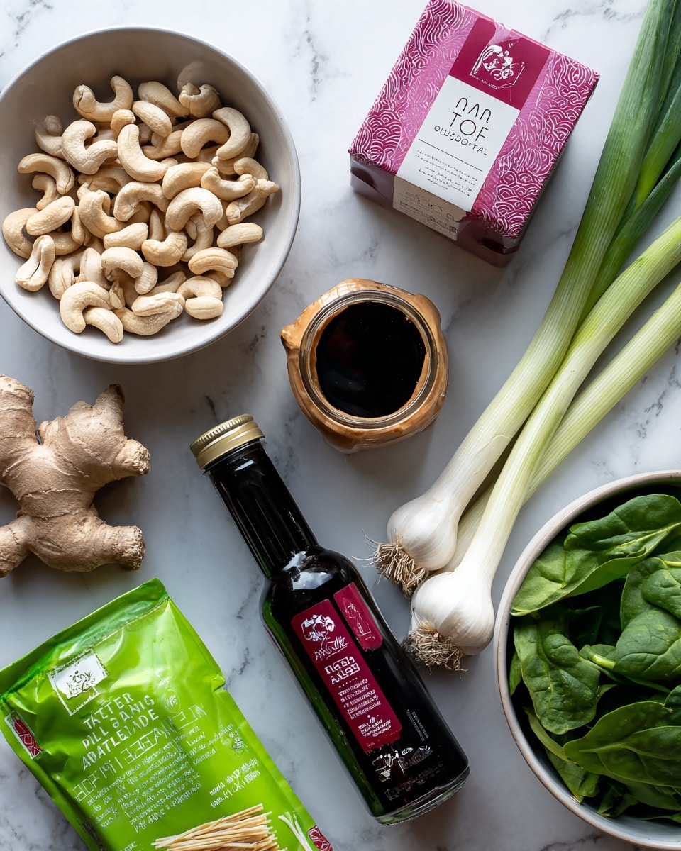 The image shows a selection of fresh and packaged ingredients arranged on a white marbled surface. On the left side, a white bowl filled with curved, light brown cashews sits next to a vibrant green package of traditional Pad Thai rice noodles. Above these, a square packet of organic tofu with a pink and beige label is placed. In the center, a small brown-lidded jar of creamy almond butter stands near a dark bottle of tamari soy sauce with a red and black label. Fresh green garlic stalks lie vertically beside the tamari bottle, and a whole bulb of garlic along with a knobby piece of fresh ginger are positioned nearby. On the right, a white bowl is full of fresh green spinach leaves, adding a natural, leafy texture to the mix. photo taken with an iphone --ar 4:5 --v 7