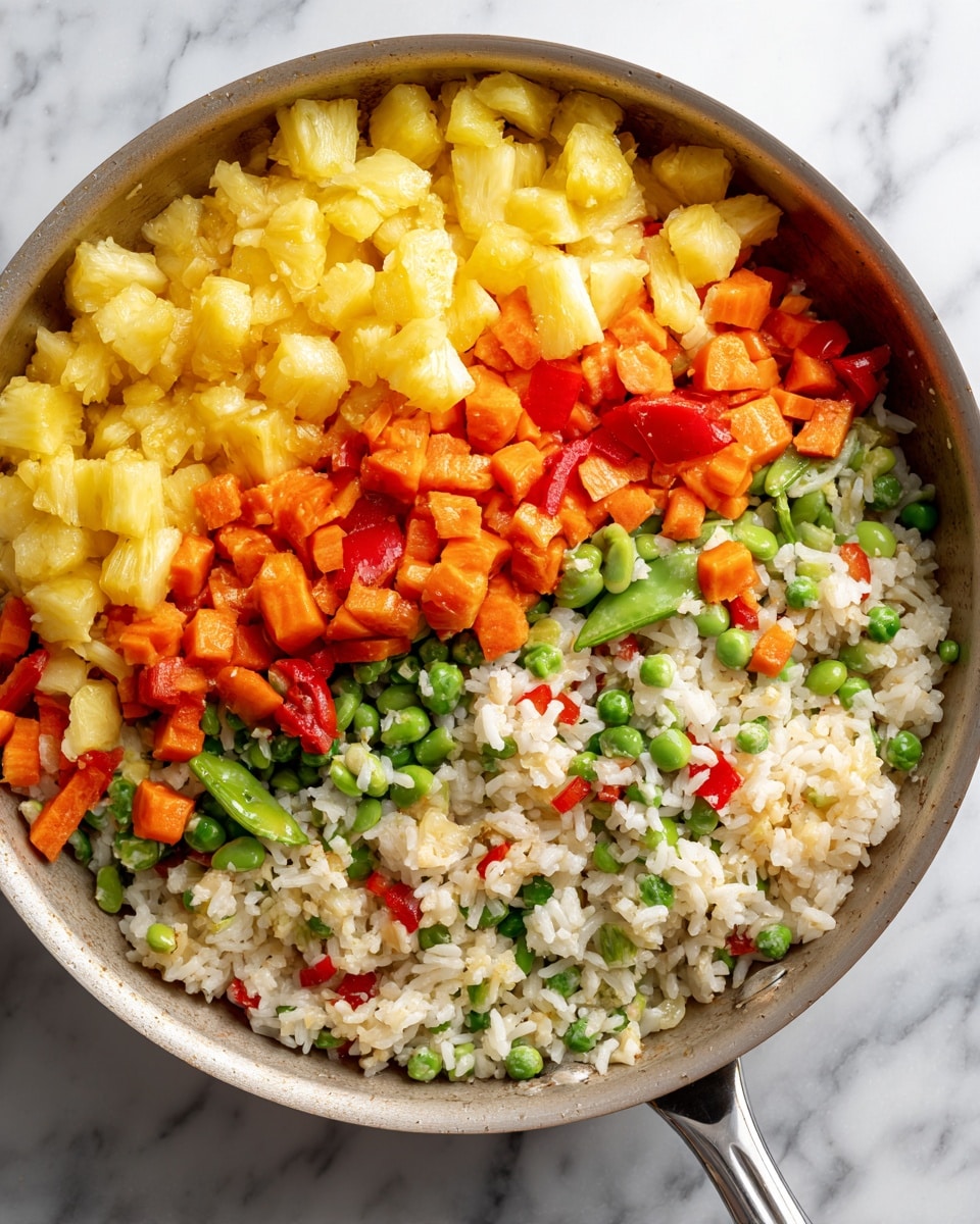 A light gray pan filled with a colorful mix of rice and vegetables sits on a white marbled surface. The dish has three main layers: the top layer shows bright yellow pineapple chunks, orange carrot cubes, and green snap peas. The middle layer is mostly white rice, mixed evenly with small pieces of red bell pepper and green edamame. The bottom layer is a blend of all the ingredients, looking fresh and well combined, with visible details of the vegetables and rice grains. Photo taken with an iphone --ar 4:5 --v 7